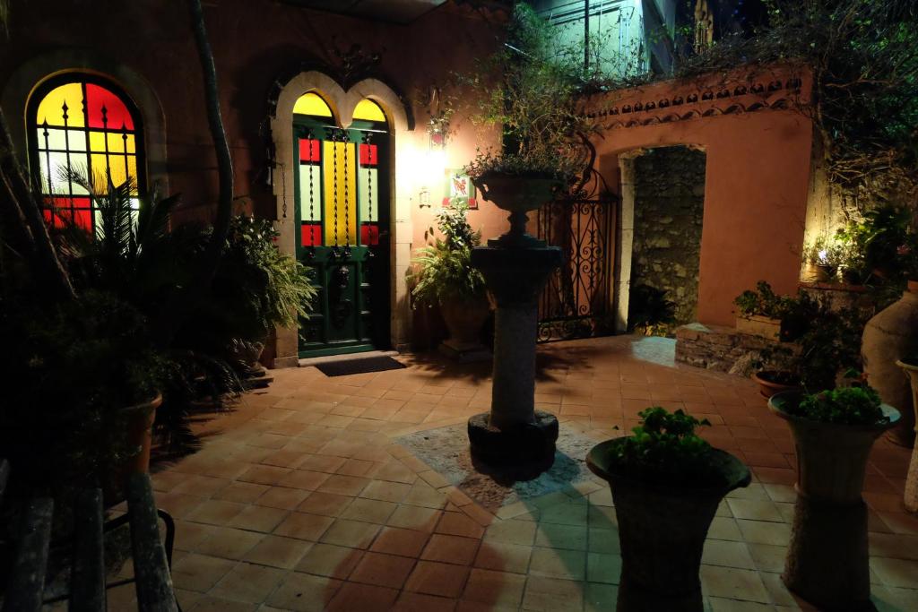 a courtyard with potted plants and stained glass windows at Hotel Villa Nettuno in Taormina