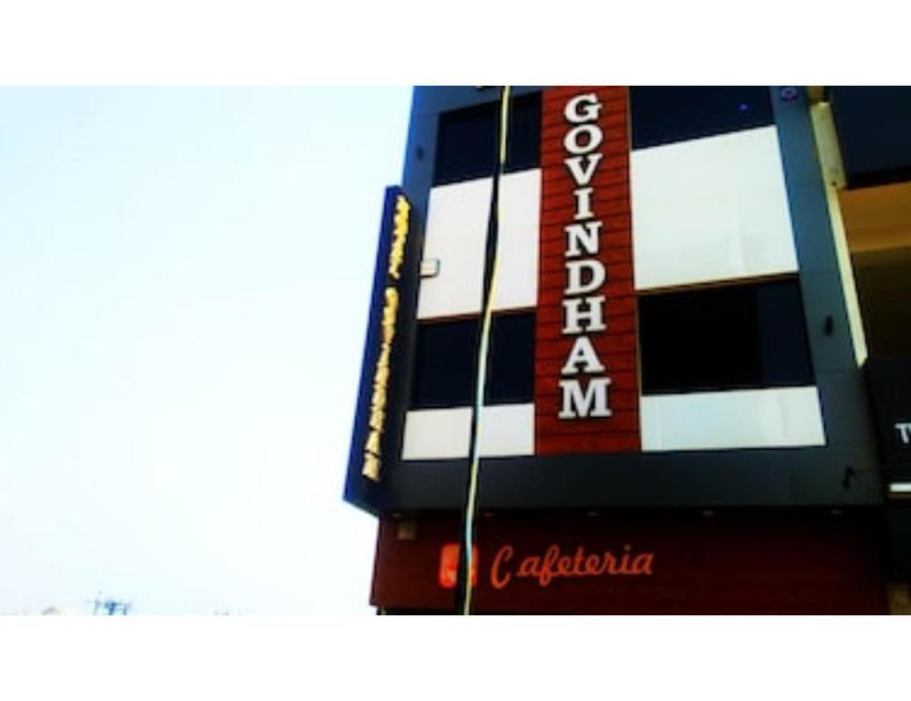 a building with a red and white sign on it at Govindham Hotel & Restaurant, Kurukshetra in Kurukshetra