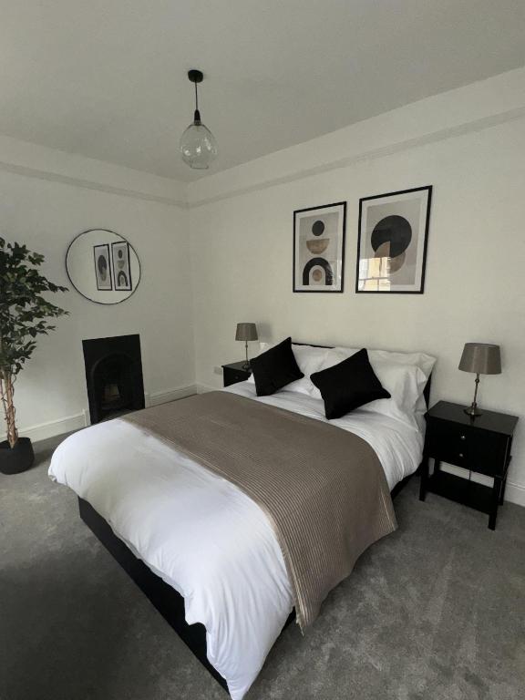 - une chambre avec un grand lit et une cheminée dans l'établissement 2 Kingsmead Square, à Bath