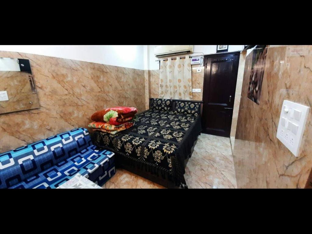um pequeno quarto com uma cama e cadeiras em Room in Guest room - Aggarwal Guest House In Cream Location em Nova Deli