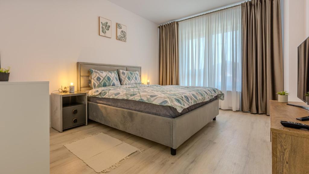 a bedroom with a large bed and a large window at Rooftop One in Braşov