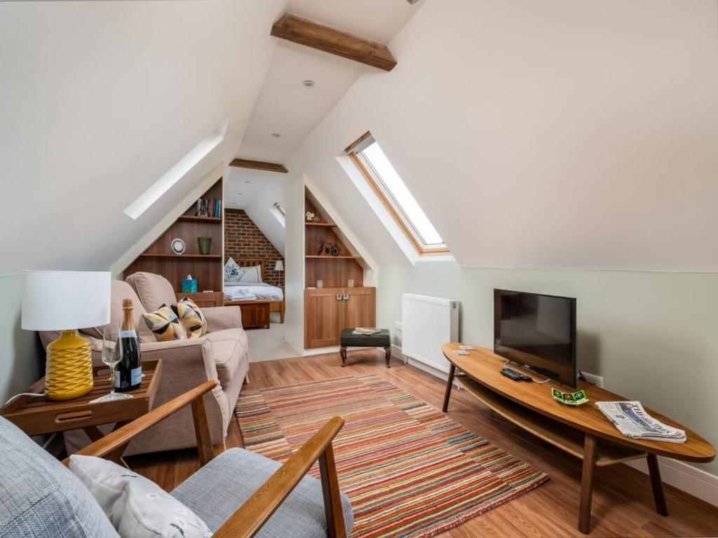 a living room with a couch and a tv at Pass the Keys Tranquil Chilterns Farm Hideaway in Little Missenden