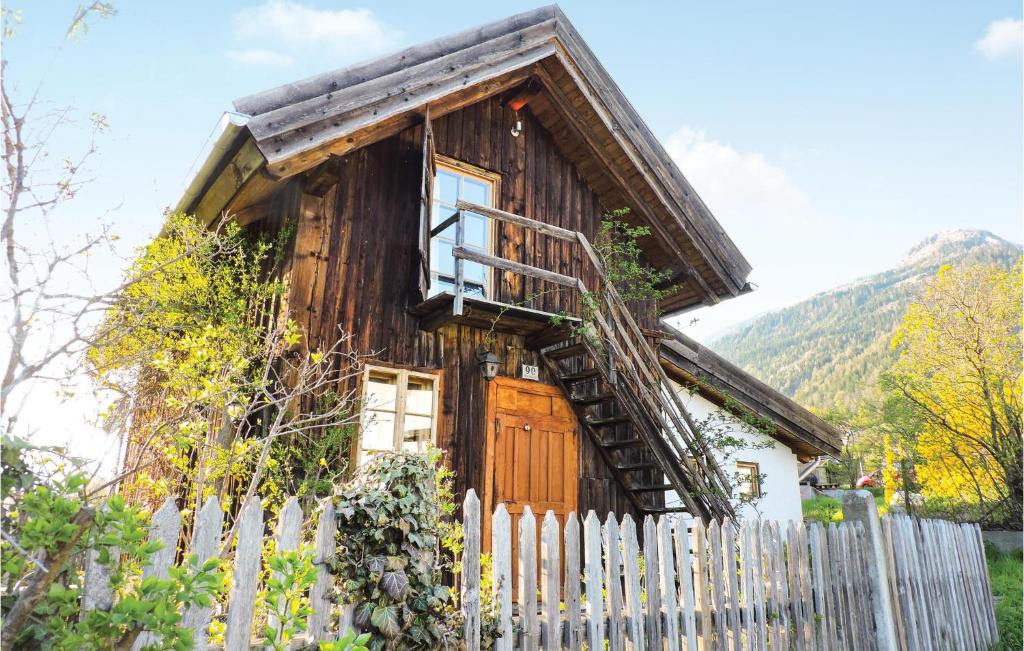 ein Holzhaus mit einem Zaun davor in der Unterkunft Awesome Home In Mhldorf With Sauna in Mühldorf