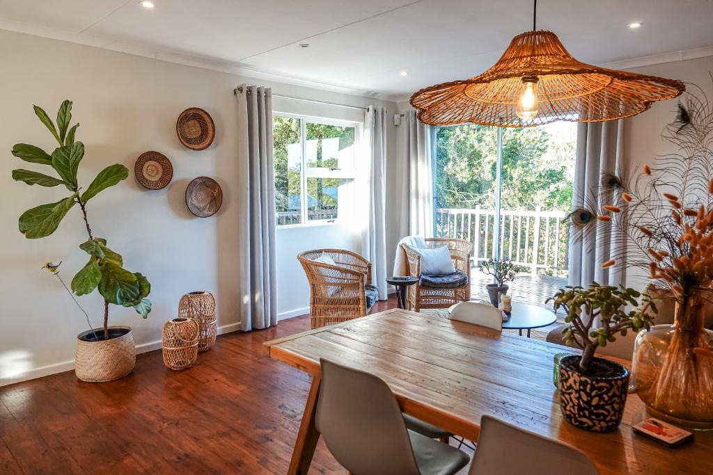 uma sala de jantar com uma mesa de madeira e cadeiras em Soutelande Eco-Hideaway - 2min Drive to Pristine Beach em Port Elizabeth