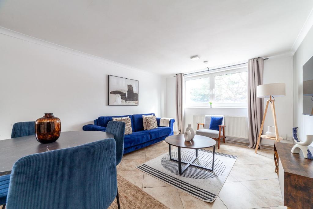 a living room with a blue couch and a table at The Archway Collection in London