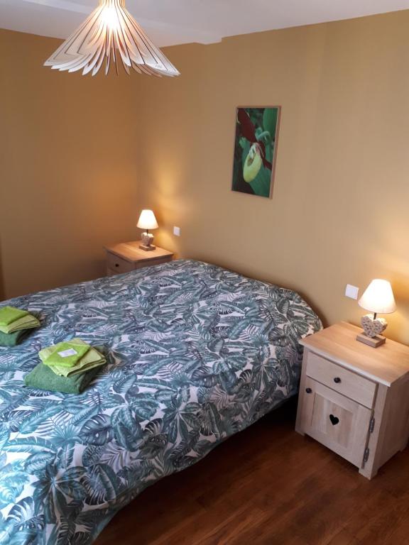 a bedroom with a bed and two night stands at Les Orchidées in Marigny