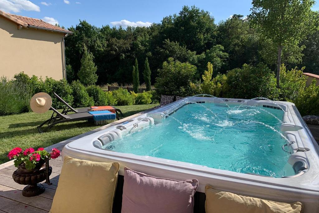 einen Whirlpool im Hinterhof eines Gartens in der Unterkunft Domaine de la Durantie - Villas avec Spa de nage in Castelnau-de-Montmiral