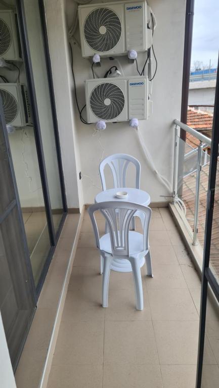 a white table and a chair on a balcony at Апартаменти за Гости ИвАя Казанлък in Kazanlŭk
