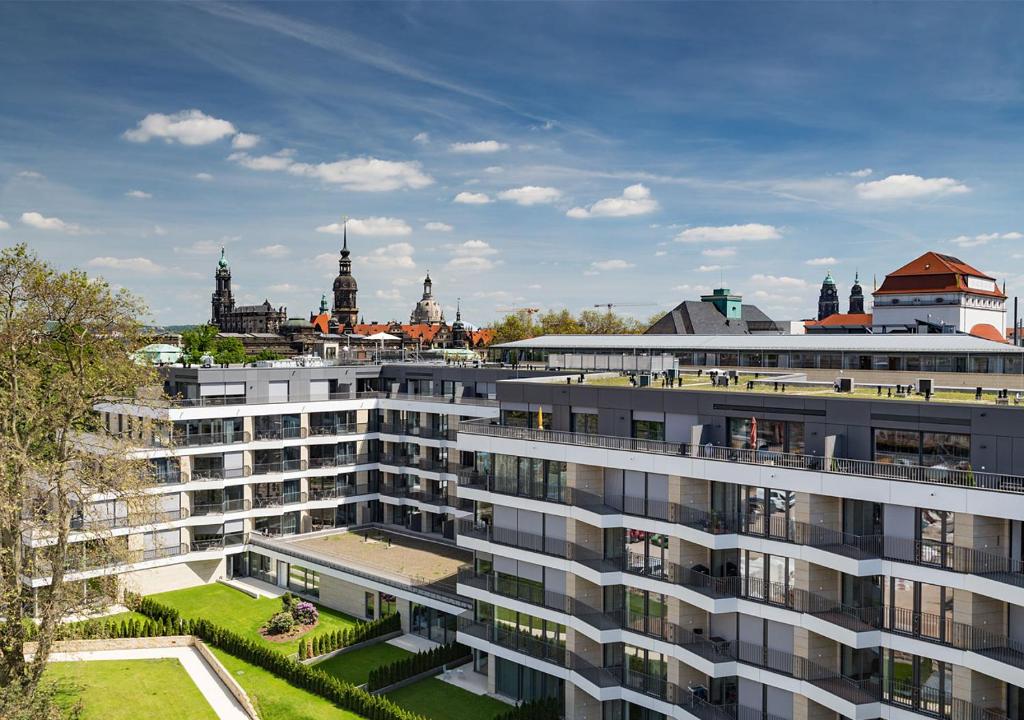 un gran edificio de apartamentos con una ciudad en el fondo en Residenz am Zwinger en Dresden