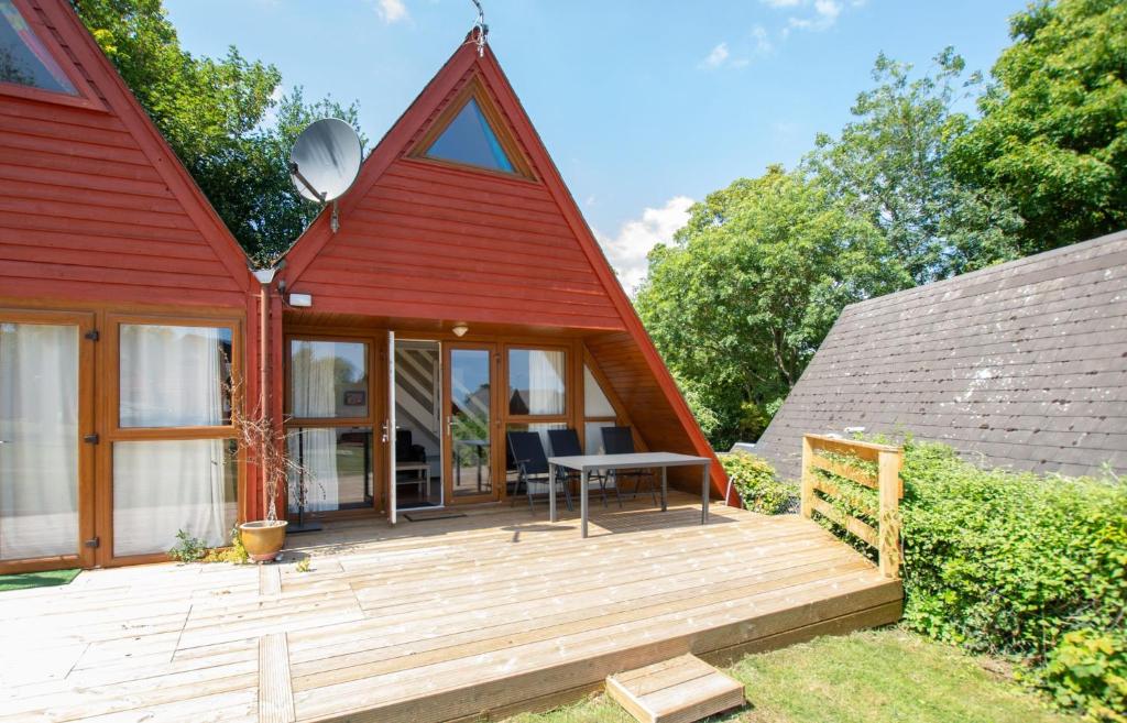 a small red house with a wooden deck at Chalet 137 in Deal