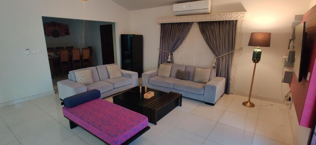 a living room with two couches and a table at Supreme Villa Block 6 Gulshan-e-iqbal Auto Generator in Karachi