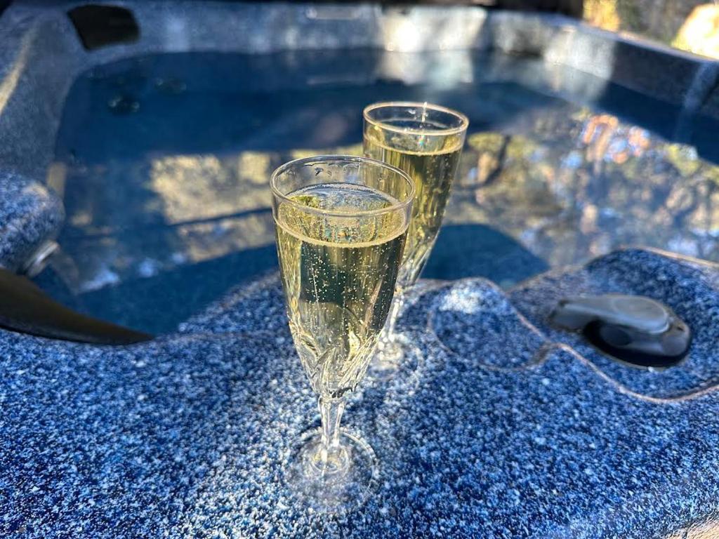 a glass of champagne sitting on a table at Suite Royale- SPA - Jacuzzi - Sauna - Massage - 2 Double Rooms - 4 SAISONS - Piscine Chauffée Toute l'année - POOL VIEW - Heated POOL -800m City Centre in Nyons