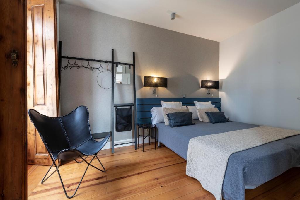 een slaapkamer met een bed en een stoel erin bij Living Lisboa Baixa Apartments in Lissabon