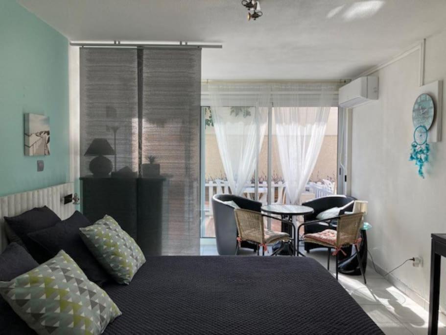 une chambre avec un lit, une table et des chaises dans l'établissement Studio 513, Port Soleil B3 au village naturiste, au Cap d'Agde