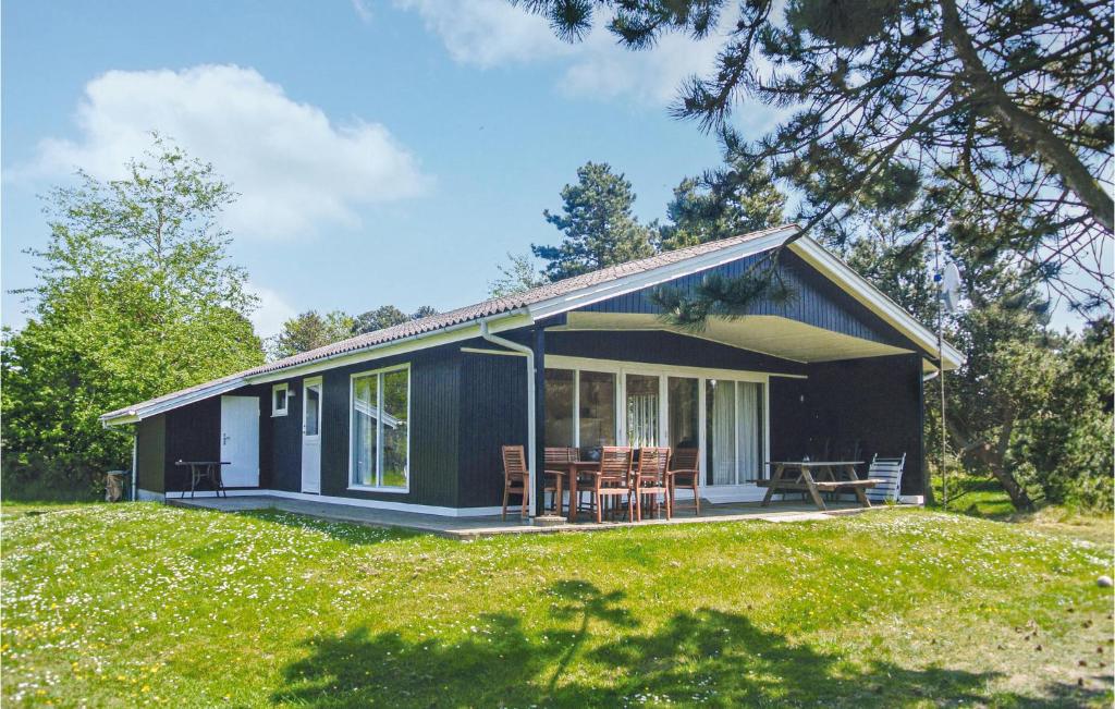 a small blue house with chairs on a lawn at Holiday Home Ristinge Sommerland Humble I in Humble