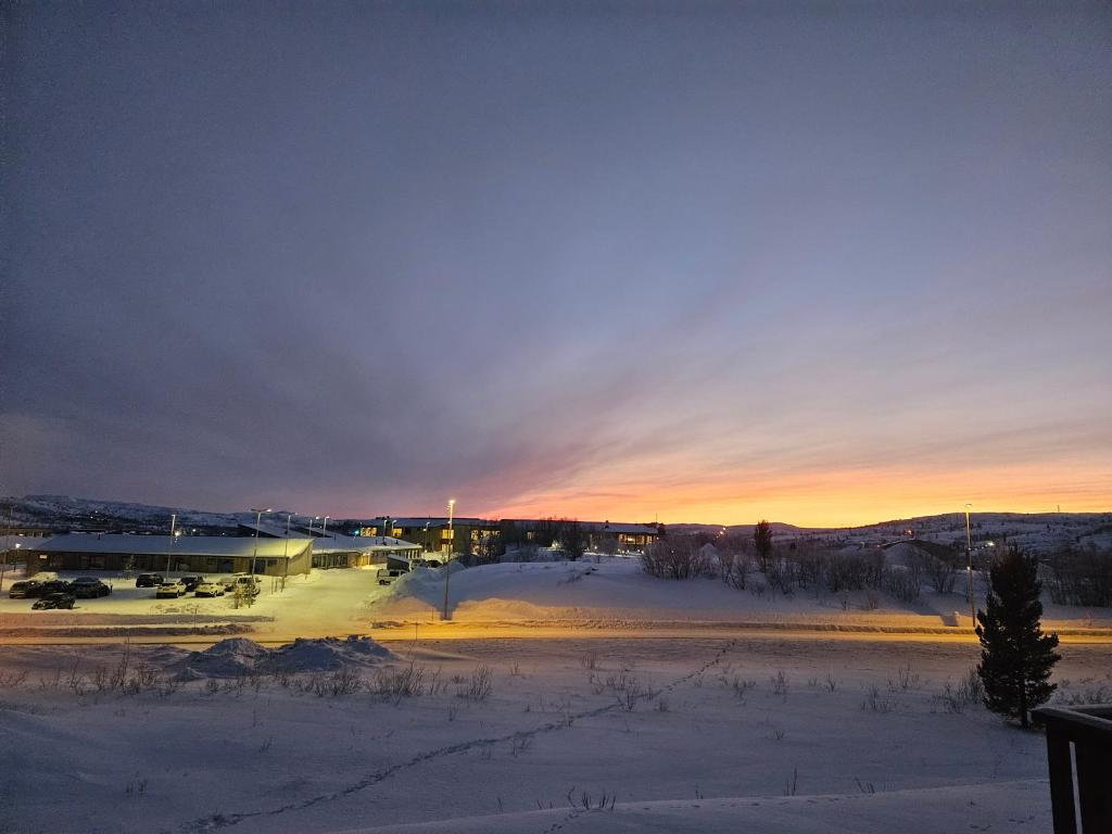 een uitzicht op een met sneeuw bedekt veld met een gebouw bij Kirkenes Interlake in Kirkenes