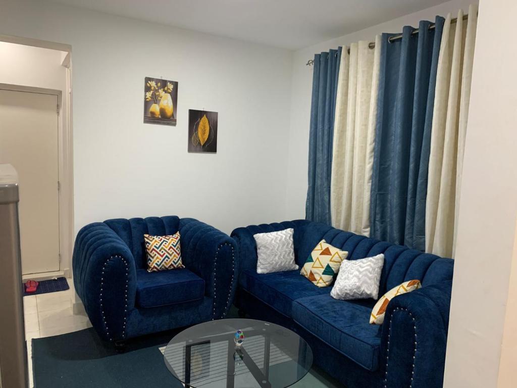 a living room with two blue couches and a table at Greenzone Apartments in Kiambu