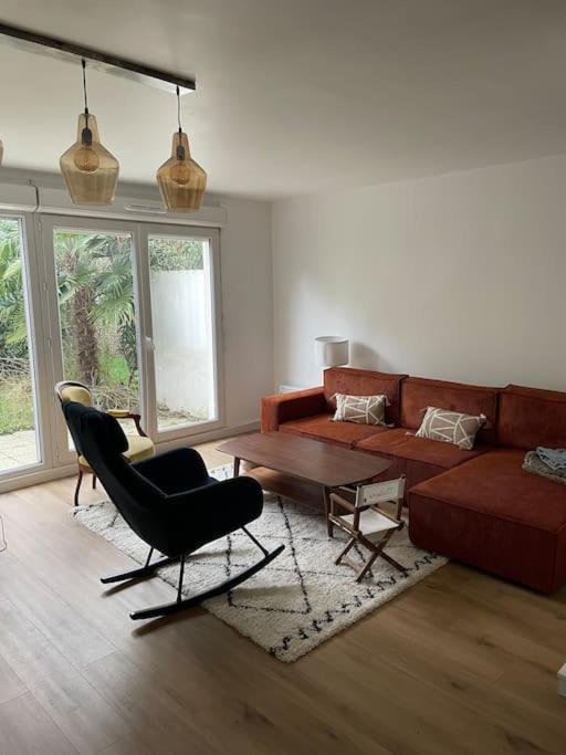 uma sala de estar com um sofá, uma mesa e cadeiras em Maison proche ville olympique et stade de France em Saint-Denis