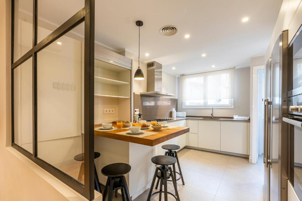 a kitchen with a counter and stools in it at Apartamento Sarria-Sant Gervasi in Barcelona