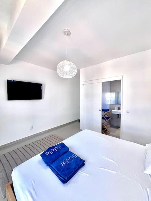 ein Schlafzimmer mit einem Bett und einem blauen Handtuch darauf in der Unterkunft Bliss Apartments T1 - Madalena in Mindelo