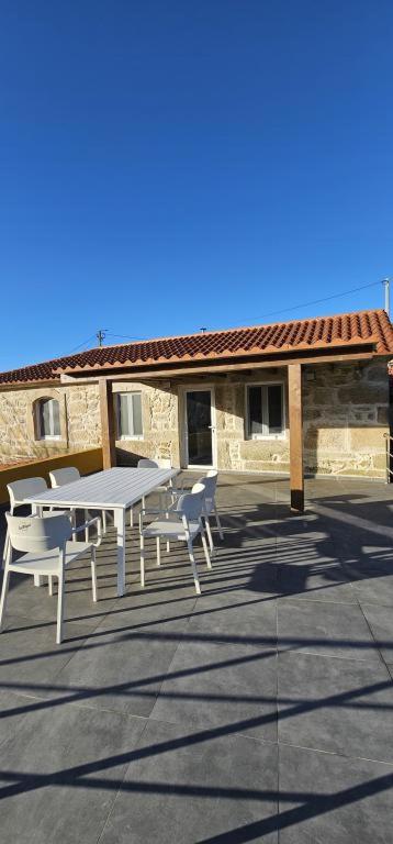 a patio with a table and chairs in front of a building at Casa Lima - AL in Valença