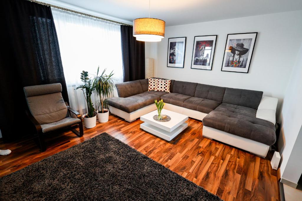 a living room with a couch and a table at Coldweek apartment - Samorin near X-bionic sphere in Šamorín