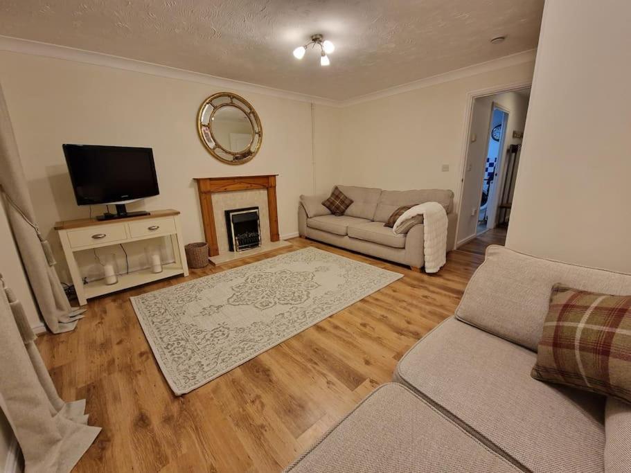sala de estar con sofá y TV en Stylish house centrally located en Bury Saint Edmunds