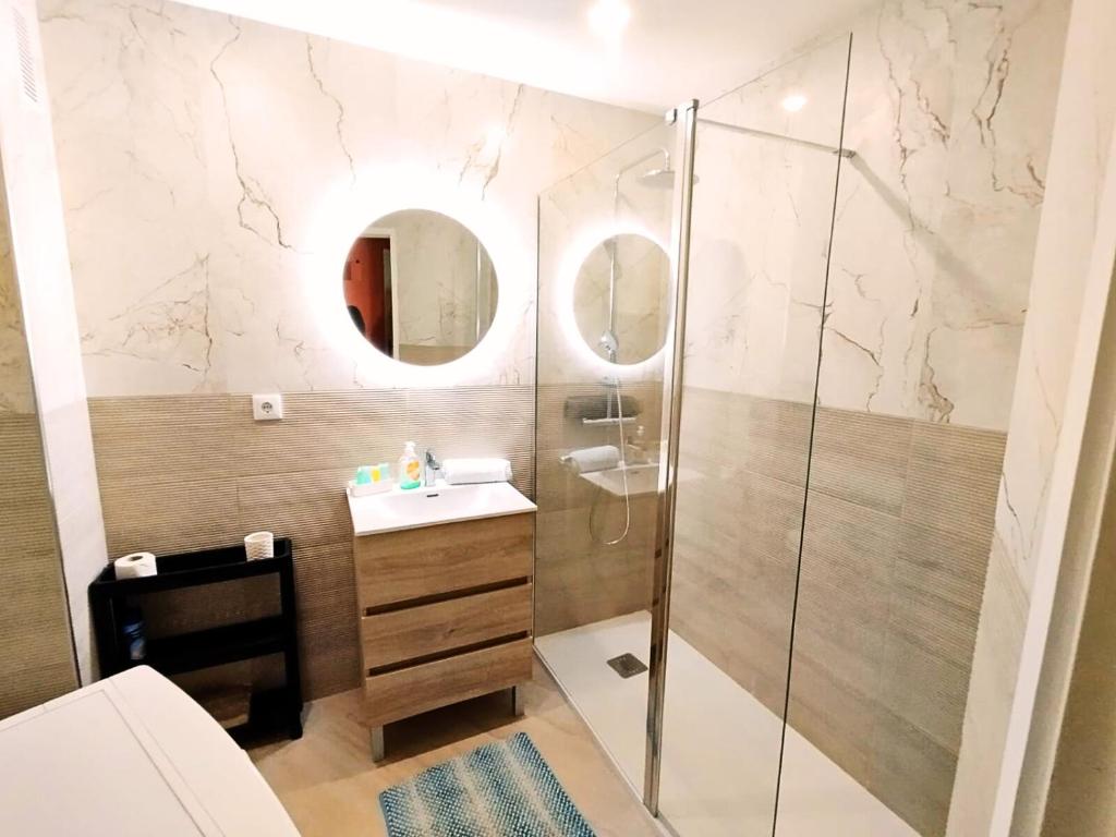 y baño con ducha, lavabo y espejo. en Appartement Praia da Rocha, en Portimão