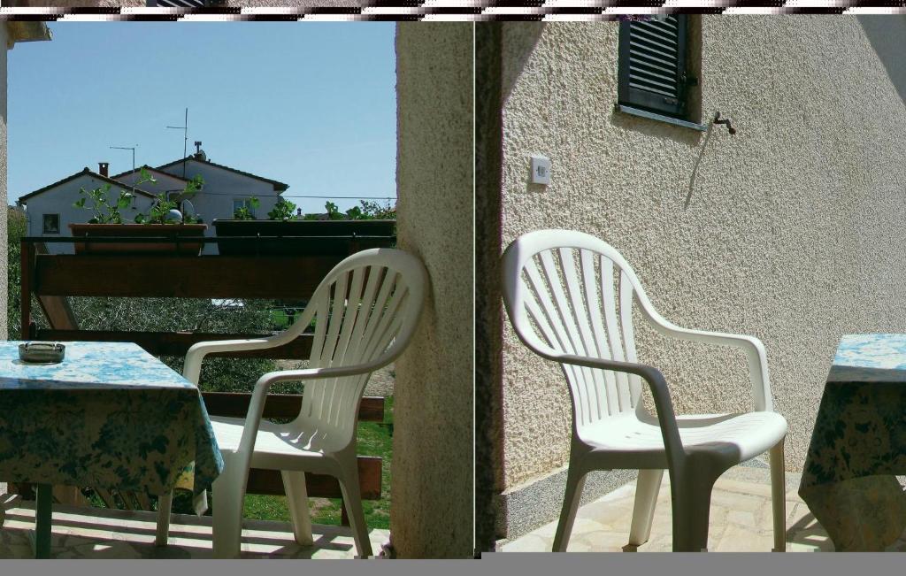 dwa białe krzesła i stół na patio w obiekcie One-Bedroom Apartment In Medulin w Medulinie