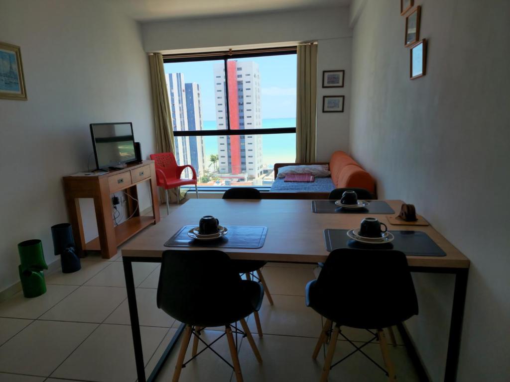 una pequeña sala de estar con mesa y sillas. en Apartamento mobiliado e confortável em candeias en Recife