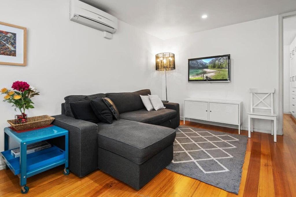 een woonkamer met een bank en een tafel bij Convenient Apartment in heart of Carlton in Melbourne