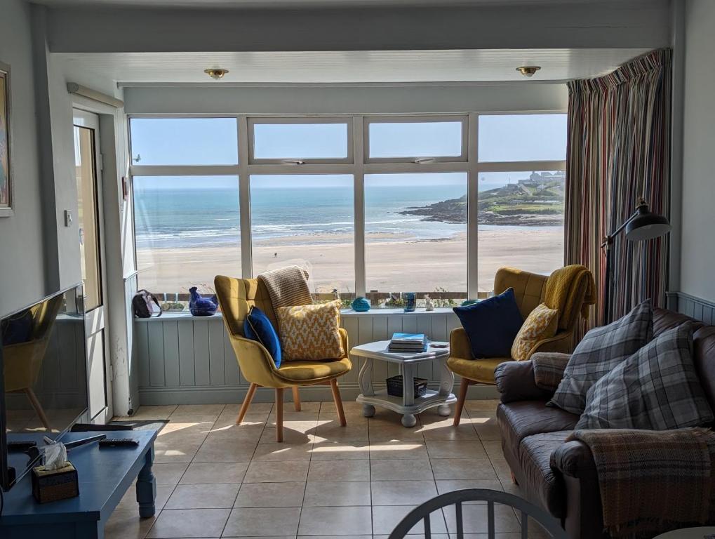 a living room with a view of the ocean at Idyllic Inchydoney Beach Cottage - Amazing sea views, path to beach! in Cork