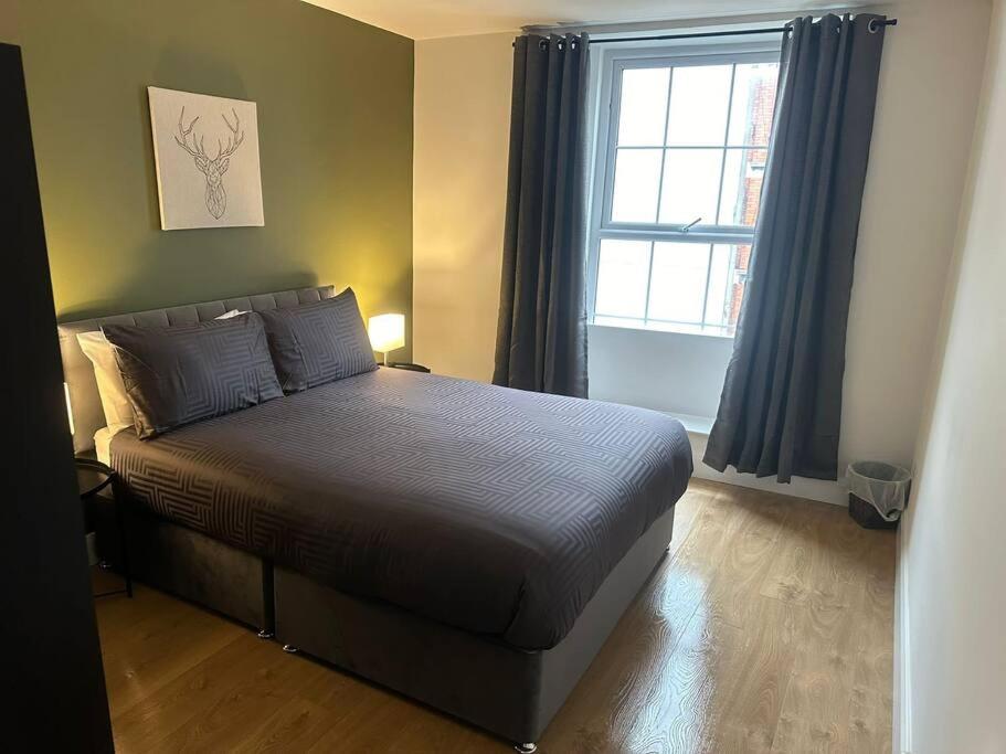 a bedroom with a bed and a window with curtains at Central Dublin Apartment in Dublin