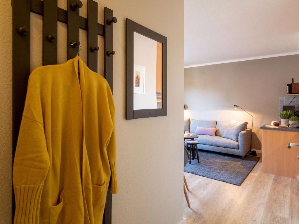 a yellow towel hanging on a door in a living room at Antares Spiekerooger Gästehaus-Sonnengartenbalkon West - Wohnung 6 in Spiekeroog