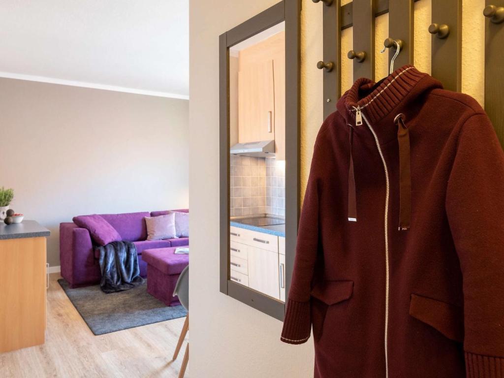 a coat hanging on a door in a living room at Antares Spiekerooger Gästehaus-Sonnengartenterrasse West - Wohnung 8 in Spiekeroog