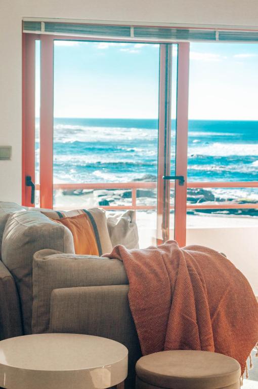 a living room with a couch and a view of the ocean at Moledo Shoreline in Moledo