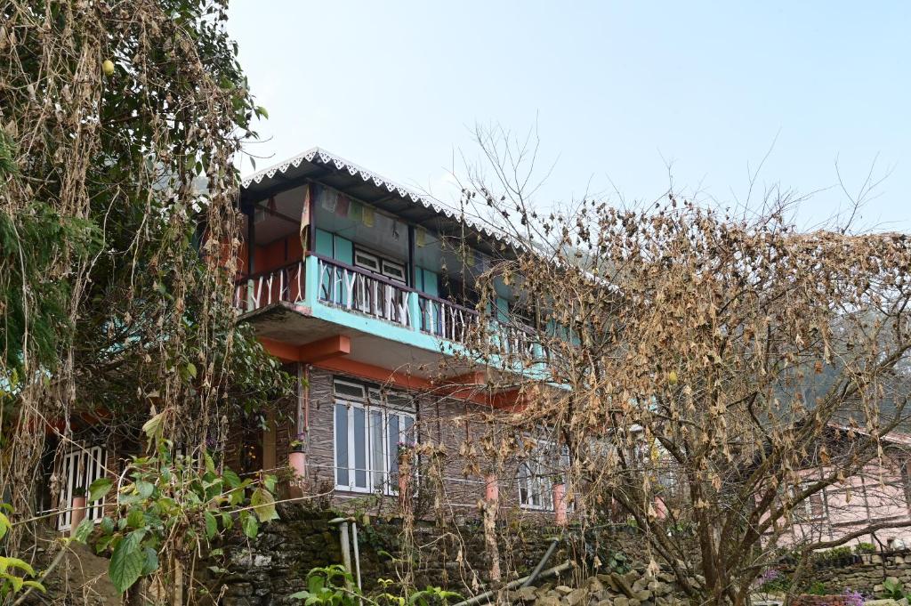 a building with a balcony on top of it at Blue Pancy Homestay in Pedong
