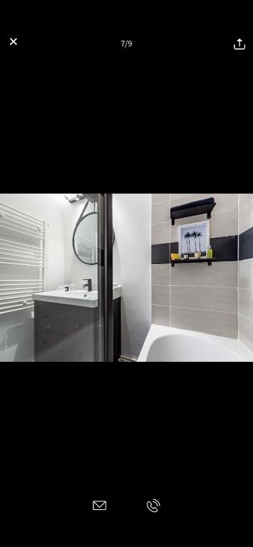a bathroom with a tub and a sink and a mirror at Superbe appartement Paris Sud: terrasse,parking in Évry-les-Châteaux
