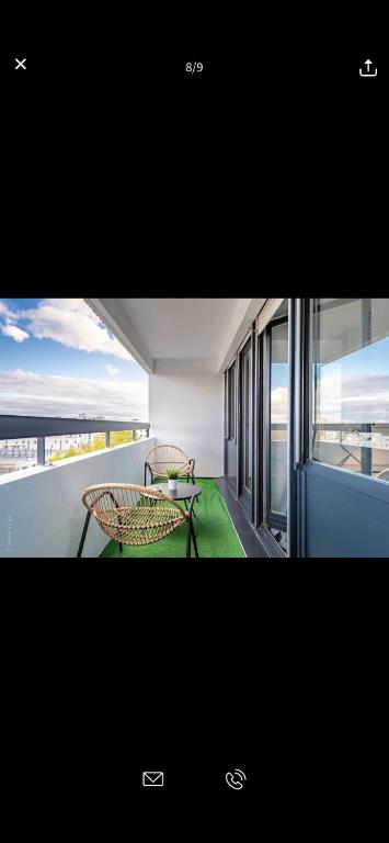 a view of a balcony with two chairs and a table at Superbe appartement Paris Sud: terrasse,parking in Évry-les-Châteaux