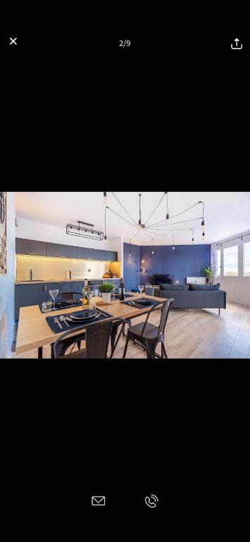 a kitchen with tables and chairs in a room at Superbe appartement Paris Sud: terrasse,parking in Évry-les-Châteaux