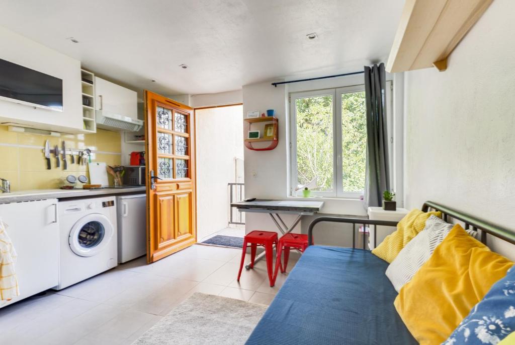 uma sala de estar com um sofá e uma mesa em Studio calme proche Paris avec terrasse privative et jacuzzi en option em Palaiseau