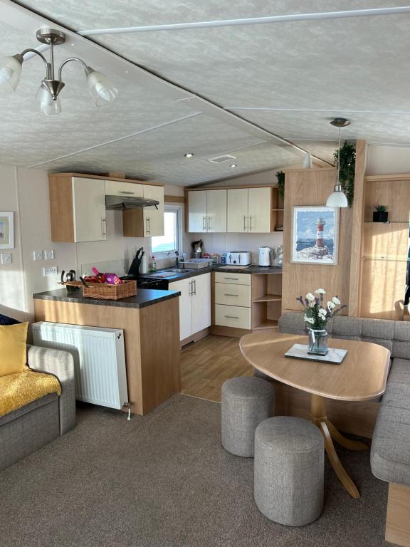 a kitchen and living room with a table and chairs at Phoenix caravan hire, Trecco bay in Porthcawl