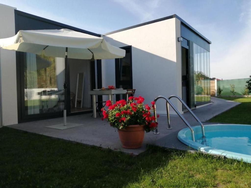 a patio with a hot tub and an umbrella at Casa Salitre in Boiro
