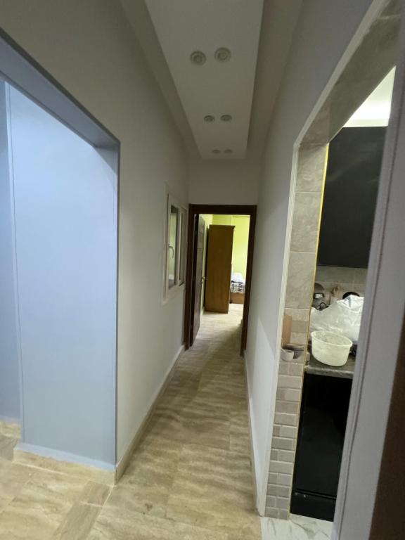 a hallway with a hallway leading to a room at بالقرب من مدينتي شقه مميزه جديده ثلاث غرف وحمامين in Badr