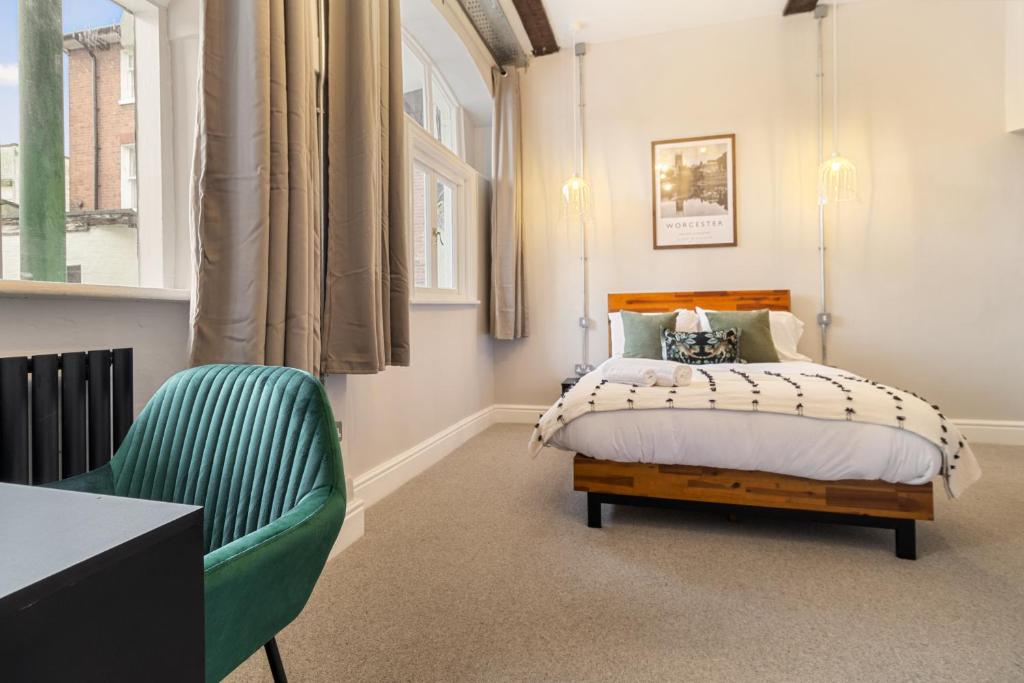 a bedroom with a bed and a green chair at WhiskAwayStays - Shaw Street - Character city centre apartment in Worcester