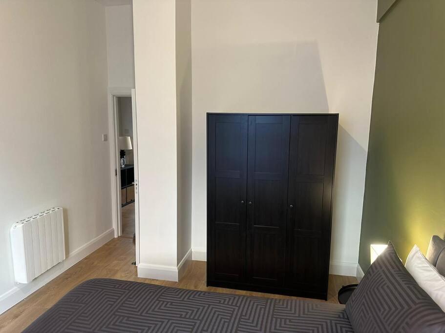 Dublin City Centre Apartment في دبلن: غرفة نوم مع خزانة سوداء في غرفة