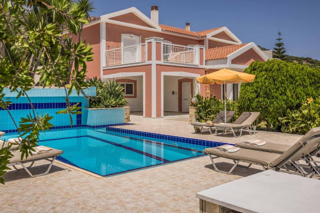 a villa with a swimming pool in front of a house at Villa Marita in Spathíon