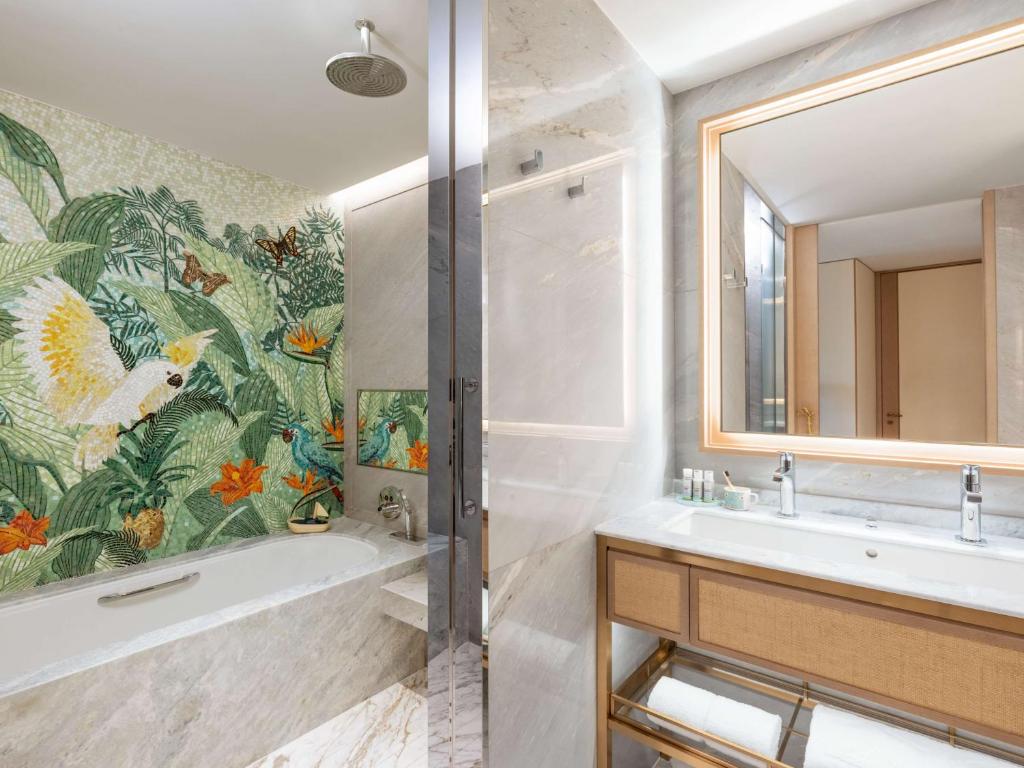 a bathroom with a tub and a sink and a mirror at Island Shangri-La, Hong Kong in Hong Kong
