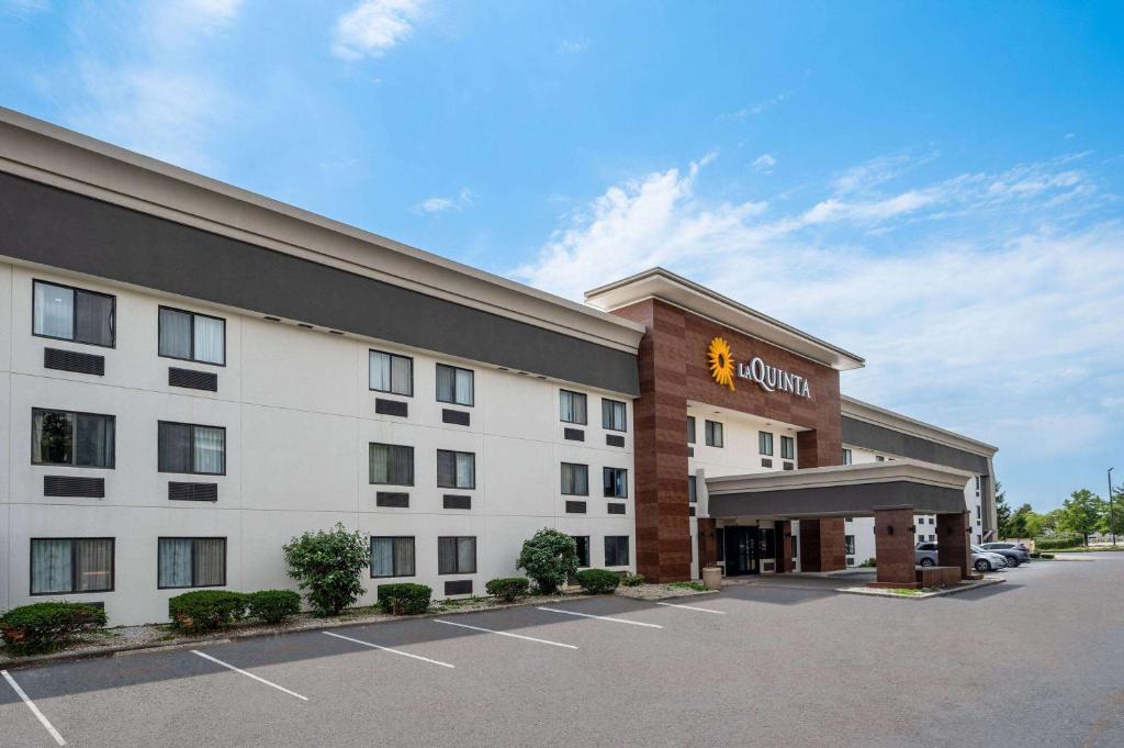 a hotel with a sign on the front of it at La Quinta Inn by Wyndham Indianapolis Airport Executive Dr in Indianapolis