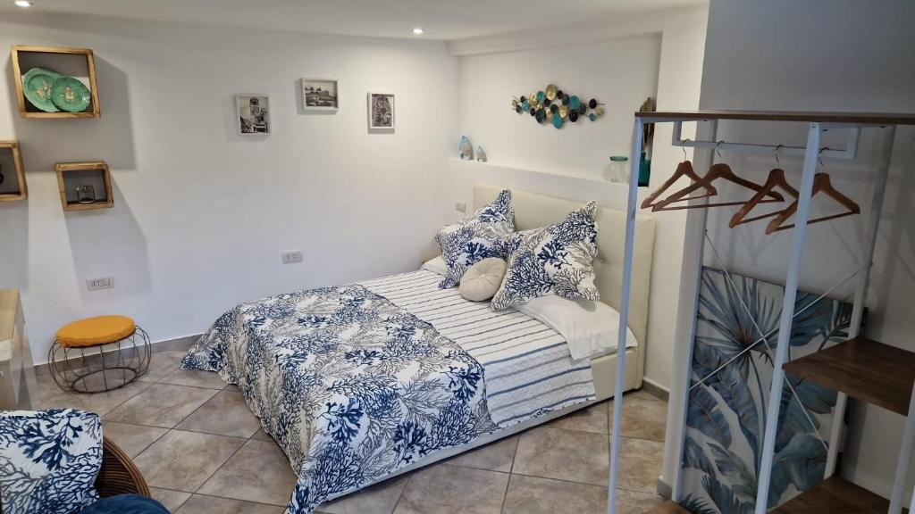 阿納卡普里的住宿－Casetta Milù，一间卧室配有一张带蓝色和白色枕头的床